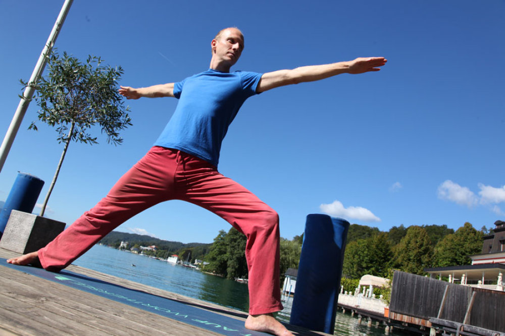 Florian Neuscheller zeigt den Krieger, eine der Figuren des Yoga
